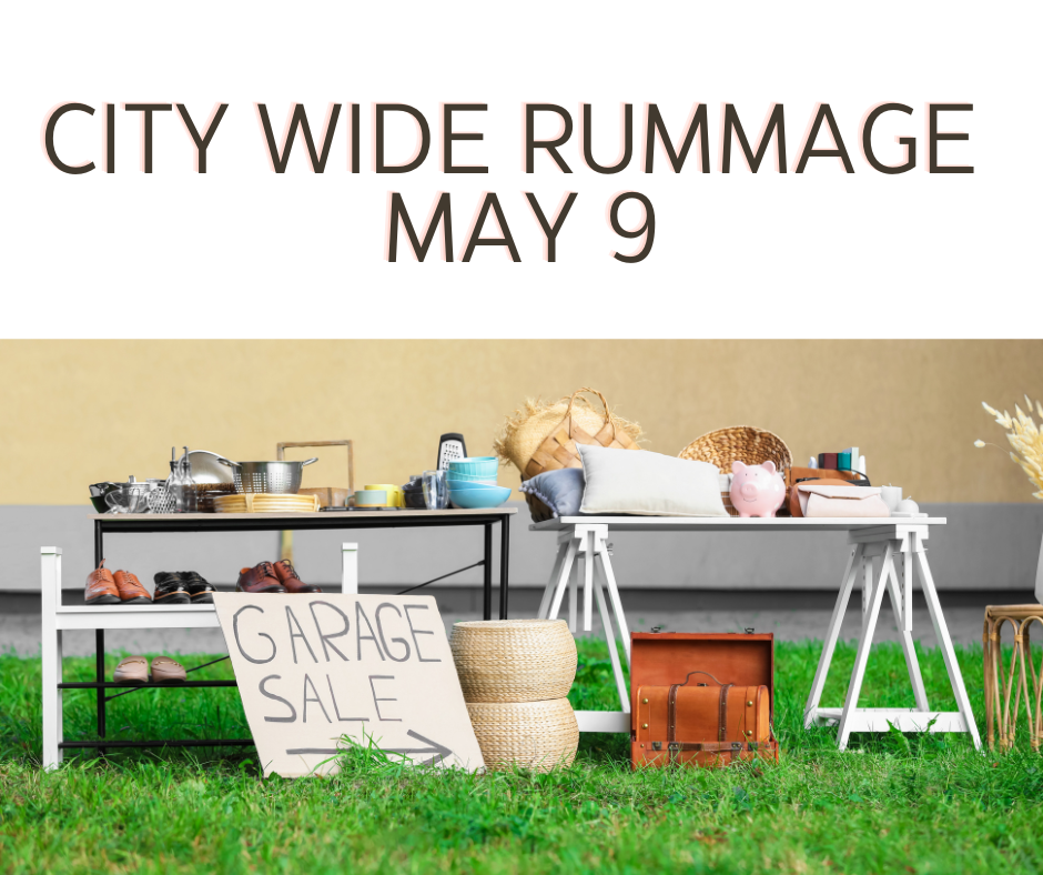 A scene depicting a garage sale setup outdoors, featuring tables with various items for sale, including shoes, kitchenware, and decorative objects. A sign announced 'Garage Sale' in bold letters, with details about a city-wide rummage sale on May 9.